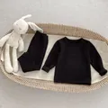 Close-up of black thermal thermal pajamas for babies neatly placed in a woven basket - 66 / Black