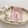 Detailed close-up of pink corduroy toddler pants with delicate lace trim at the ankles - Lotus Pink / 73