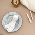 Detail von weißer Baby-Leggings aus Rippbaumwolle, gefaltet auf einem Steintablett - S (12-24 Monate) / Weiß