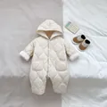 Detalle del patrón de rombos y forro polar en el mameluco beige con capucha para bebé - Talla 66 / Mameluco