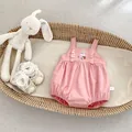 Detail eines rosa Baby-Stramplers mit Hasen-Stickerei und Spitzenkragen aus Baumwolle - 66cm / Hosenträger Strampler