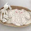 Close-up of floral baby bodysuit with Peter Pan collar and pink bow accents - 66cm / Floral