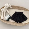Detailed view of baby girl cotton shorts with large bow and lace ruffled toddler shoes - Black