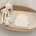 Detail view of beige ribbed baby tank top with red bow prints and size 66 label - 73cm / Apricot And Pink Bowknot