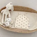 Detail of baby girl camisole with bow print and size tag in a woven basket - 90cm / Apricot And Black Bowknot