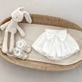 Detailed view of baby white bloomer with large bow in a woven basket display - 73cm / White