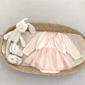 Detail eines rosa Baby-Tüllkleid-Sets mit Cardigan in einem gewebten Geschenkkorb - Rosa / 90cm