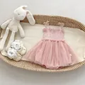 Detailed flat lay of a pink tutu romper with mesh skirt in a woven baby basket - 66CM / Pink