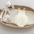 Detail of cream tulle baby bodysuit dress and lace shoes with a plush bunny in a basket - 66CM / White