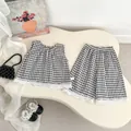 Detailed flat lay of toddler plaid set with lace trim and embroidered sleeveless top - 73cm / Black White Grid