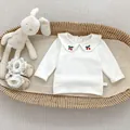 Detail van beige katoenen babyblouse met Peter Pan-kraag en geborduurde kersversiering - 73 / Tops