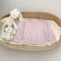 Detail van roze babyvestje met zachte geribbelde textuur en vier witte knopen - Paars / 73cm