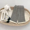 Detailopname van gestreepte gebreide babybroek met franjes onderaan de pijpen - Gestreept / 73cm