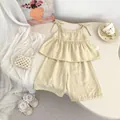 Detail of baby girl summer cotton linen set featuring wood buttons and bow shoulder straps - 73 / Yellow