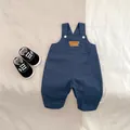 Detailed flat lay of navy blue baby overalls with Happy Duck embroidery and canvas shoes - 66cm / Dark Blue Overalls