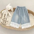 Detail of girls' light blue denim wide-leg pants with elegant white lace embroidery hem - 73 / Blue