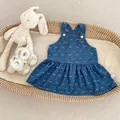 Pinafore de mezclilla azul marino para bebé con lazos blancos sobre bandeja de paja - Azul / 73