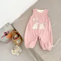 Close-up of pink corduroy baby romper featuring cute white rabbit embroidery and plush pom-poms - 66 / Pink