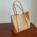 Borsa tote in pelle beige minimalista con cuciture su superficie in legno - Cachi Sale Chiaro