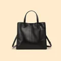 Borsa tote minimalista in vera pelle nera con cuciture verticali e tracolla regolabile - Nero