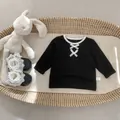 Detail van zwart katoenen meisjesshirt met witte strikjes en kanten leren schoenen - 73cm / Zwart