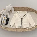 Gebreid beige babyvestje met matrozenkraag en knuffelkonijn in een rieten mand - 73cm / Abrikoos
