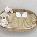 Close-up of khaki cotton baby shirt featuring an oversized white lace collar and buttons - Long Sleeve Lace Lapel Shirt / Khaki / 73