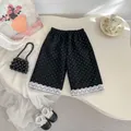 Detailansicht der schwarzen Polka-Dot-Mädchenhose mit weißem Spitzenbesatz am Saum - 73 / Schwarz Gepunktete Hose