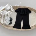 Primer plano de pantalones acampanados negros para niñas pequeñas con detalle de volantes - 73cm / Negro