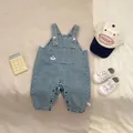 Detail of baby denim overalls with panda pocket, adjustable straps and snap crotch button - Overalls / 73cm