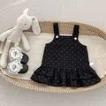 Detalle de vestido de lunares para bebé con volantes en una cesta de mimbre tejido - 73cm / Vestido de tirantes