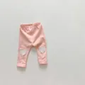 Detailed macro view of soft pink cotton baby pants with heart-shaped knee patch detail - 66 / Pink