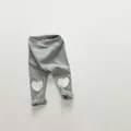 Detail view of grey knitted baby leggings with white heart patches on the knees - 66 / Gray