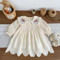 Detalle de vestido para bebé con bordado floral, cuello de encaje y diseño calado - Vestidos / 73cm