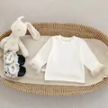 Detail van crème baby shirt met lange mouwen, kanten manchetten en zwarte schoentjes - Crèmewit Shirt met Lange Mouwen / 73