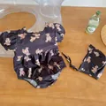 Dettaglio del costume bimba con stampa orsetto, maniche a sbuffo e cappello abbinato - Nero / Taglia 73
