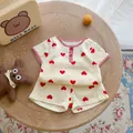 Flat lay view of a cream cotton muslin baby set with red heart prints on wooden background - 66cm / Red Heart