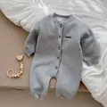 Dettaglio di una tutina neonato in cotone grigio spesso con ricamo BONITO e bottoni - Grigio