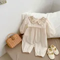 Close-up of baby floral Peter Pan collar romper with lace trim and lantern sleeves - 66 / Apricot