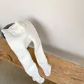 Detalle de mallas de punto blanco grueso para bebé sobre un taburete de madera - M / Blanco Con Forro Polar
