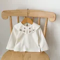Detail of baby girl cotton top showing floral embroidery on Peter Pan collar and ribbed fabric - White Top / 73cm