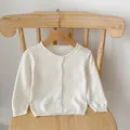 Close-up of the delicate heart-shaped hollow knit pattern and white round buttons - White