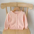 Detailed view of heart-shaped hollow knit pattern on pink baby cardigan sweater - Size 66 / Pink
