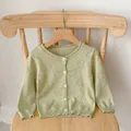 Close-up of mint green knitted baby cardigan with hollow heart pattern and white buttons - Size 66 / Matcha Green