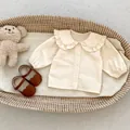 Infant girl beige long sleeve shirt with ruffle Peter Pan collar and elastic cuffs - 66CM