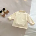 Detailed flat lay of cream-colored baby mock neck top with soft ribbed cotton texture - 66cm / Pale Yellow