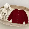 Donkerrood gebreid babyvest met houten knopen en kabelpatroon in een gevlochten mand - 66cm / Kersenrood Cardigan