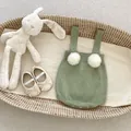 Vue détaillée du barboteuse tricotée vert sauge pour bébé avec pompons blancs et chaussures - 100 / Vert clair