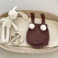 Détail d'une barboteuse bébé en tricot avec pompons et pressions dans un panier - 73 / Brun Rougeâtre