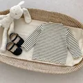 Gestreiftes Baby-Langarmshirt mit Rüschensaum und Mary Jane Schuhen im Weidenkorb - 66CM / Schwarz Gestreift
